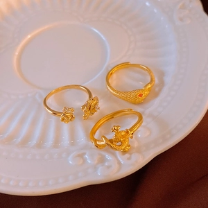 Detailed view of three vintage gold rings featuring dragon, snake, and floral designs