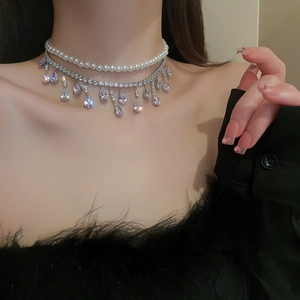 Elegant double-layered necklace featuring white pearls and a rhinestone teardrop pendant