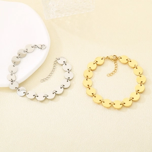 Detail of round disc chain bracelets in gold and silver finish with lobster clasp