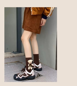 Close-up of cute 3D bear plush accessory on mid-calf socks with casual sneakers