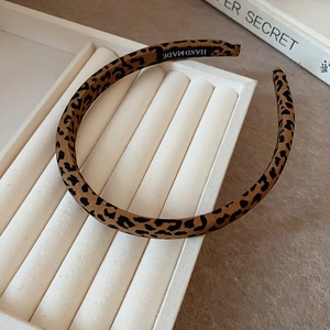 Détail du serre-tête fait main à motif léopard avec texture en tissu sur un plateau