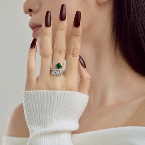 Detail of S925 silver ring with square emerald stone and small diamonds on model finger