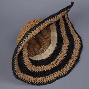 Close-up of handmade woven straw hat interior with striped pattern and sweatband