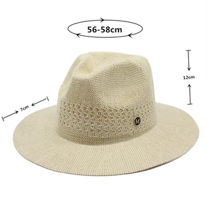 Détail chapeau Panama beige montrant bord de 7cm et emblème métallique doré M