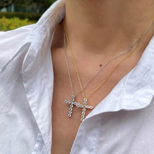 Close-up of elegant S925 silver and gold cross necklaces with zircon inlays on neck