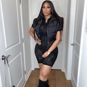 Sexy black mesh cutout bodysuit paired with a cropped puffer vest on a model in a hallway
