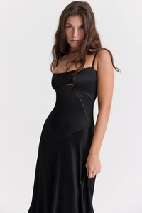 Detail of the high-quality black satin fabric and precise tailoring of the slip dress