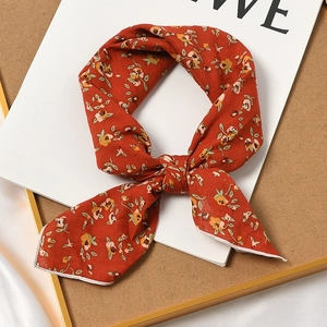 Red floral cotton linen scarf tied in a bow on a book tray for autumn and winter style