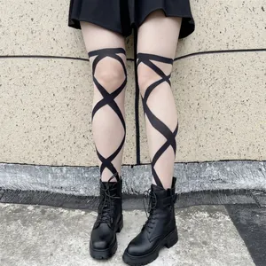 Detail of black pantyhose with criss-cross pattern styled with platform boots