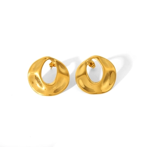 Gros plan sur des boucles d'oreilles créoles dorées 18K avec surface ondulée artistique