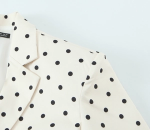 Gros plan du col et de l'épaule d'un blazer à pois avec texture de tissu tissé de qualité
