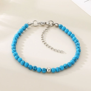Détail macro de perles texturées bleu ciel avec fermoir mousqueton et pendentif cœur
