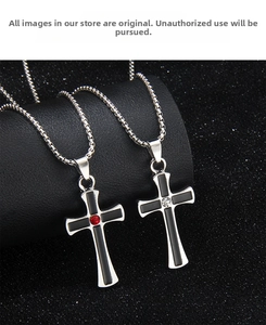 Detail of couple cross necklaces with black enamel and sparkling red and white crystals