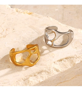 Detailed view of 18K gold and silver irregular open rings on a natural stone base