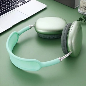 Close-up of green wireless headphones on a desk with metal slider and fabric ear pads