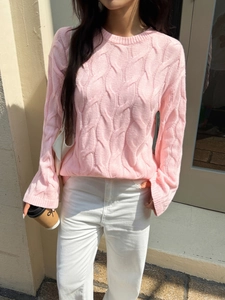 Detailed knit texture of pink cable knit crewneck sweater with a minimalist casual design