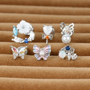 Détail d'un ensemble de 6 boucles d'oreilles papillon et fleur sur un plateau en velours