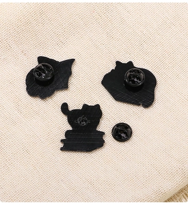 Detail view of the metal lapel pin back with black coating and butterfly clutch fasteners