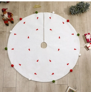 Vue détaillée du tapis de sapin blanc en peluche avec motifs sapins rouges et pompons