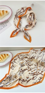 Detailed view of accordion pleated scarf with magnolia print and orange contrast edges