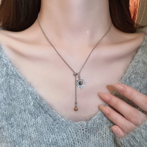 Gros plan d'un collier pendentif tournesol argenté avec œil de tigre sur un mannequin