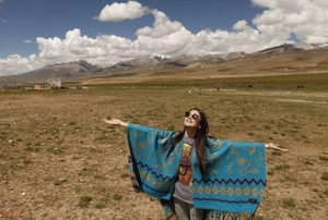 Outdoor view of a blue ethnic style thick cashmere shawl with floral and geometric patterns