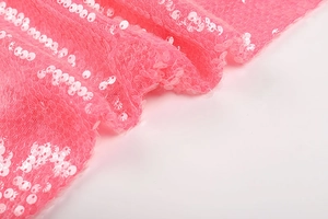 Macro shot of pink sequin fabric on mesh base for evening dress detailing