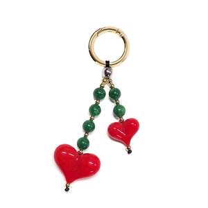 Detailed close-up of beaded keychain with green spheres and red heart pendants