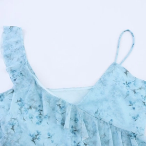 Detailansicht eines hellblauen Blumenkleides mit Netzstoff, Trägern und Rüschen am Ausschnitt