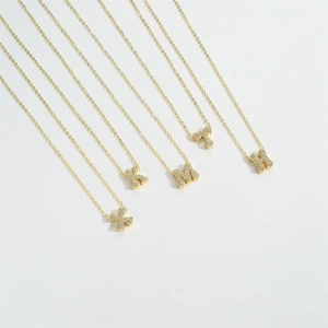 Detail view of five gold initial necklaces X K M T H with pave zircon settings