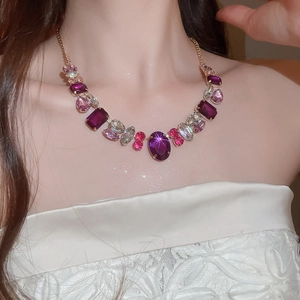 Detail of vintage geometric necklace with multi-colored crystals and gold-tone chain on model