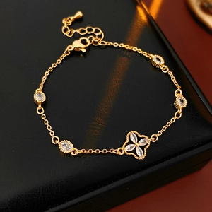 Detail of adjustable gold bracelet featuring zircon flower pendant and oval crystals