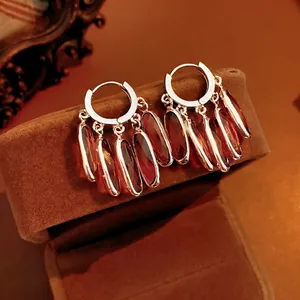 Vintage gold hoop earrings with multi-faceted red glass pendants on brown velvet