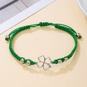 Detailed view of green braided rope bracelet with silver beads and hollow clover charm