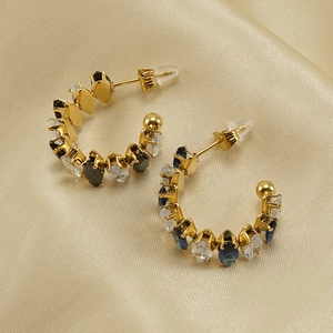 Dettaglio di orecchini in acciaio 18K con gemme blu a taglio marquise e rotondo su raso