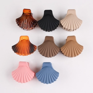 Detail of shell-shaped hair clips in various colors including amber, beige and blue