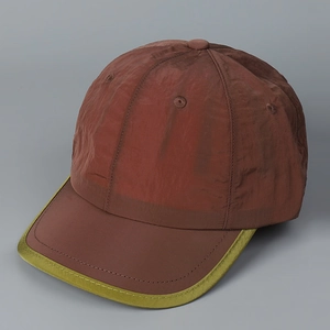 Détail d'une casquette en nylon bordeaux avec bord vert citron et structure 6 pans