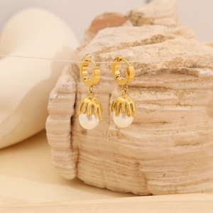 Detail of gold U-shaped earrings with irregular water-drop pearls in a modern style