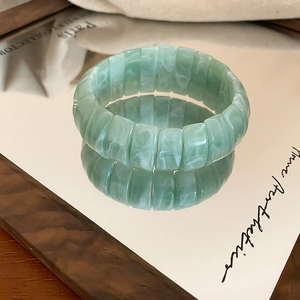 Detail of light green marble-textured elastic bracelet with modular resin links