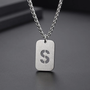 Détail du pendentif rectangulaire argenté avec lettre S ajourée sur chaîne en acier
