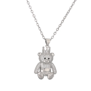 Sparkling silver teddy bear necklace pendant with crown and rhinestones on white background