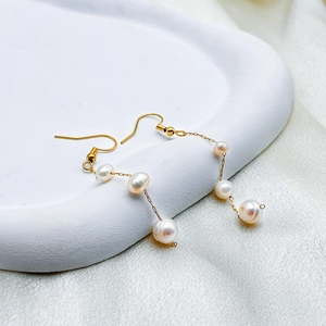 Vue détaillée des boucles d'oreilles longues en plaqué or 14K avec perles baroques