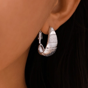 Boucles d'oreilles créoles demi-lune en argent avec rayures mates portées sur l'oreille