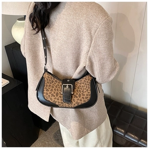Sac bandoulière chic à motif léopard et cuir noir porté avec un blazer beige