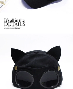 Detail of black baseball cap featuring cat ears and integrated dark aviator goggles