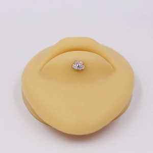 Macro detail of silver paw piercing jewelry with pink zircon stones on skin model