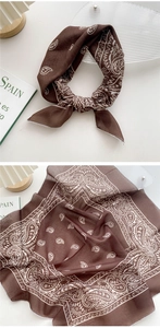 Detail of dark brown cotton scarf featuring white paisley pattern and soft texture