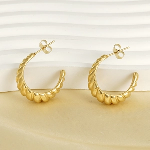 Chic 18K gold plated stainless steel twisted croissant hoop earrings on silk background
