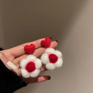 Detail of red flocked heart and white tulip earrings with wool felt texture and needle posts