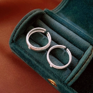 Detail of silver brushed rings with zircon in a dark green velvet jewelry box